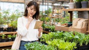 園芸店で家庭菜園初心者向けの野菜の種を選ぶ日本人女性